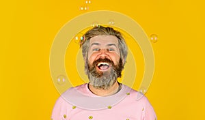Summer vacation. Infantility concept. Happy playful bearded hipster and soap bubbles. Happiness and joy. Good mood. Play
