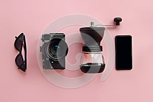 summer vacation. instagram blogging. stylish black sunglasses,smartphone,coffee grinder and photo camera on pink background, flat