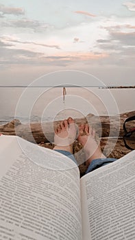Summer vacation. man laying on sun lounger reading book with beautiful view view on sea.