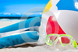 Summer vacation. Mask goggles and color ball on beach background