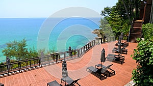 Summer vacation in modern resort. Empty sun lounges with umbrellas in luxury hotel with view on turquoise sea. Concept