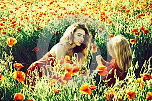Summer vacation. mothers day, girl and little boy in field of poppy
