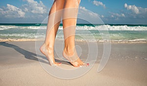 Closeup of woman legs walking on beach sand