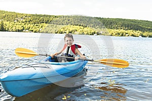 Summer vacation Portrait of happy cute boy kayaking the on river