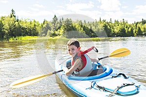 Summer vacation Portrait of happy cute boy kayaking the on river