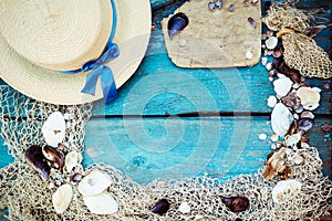 Summer vacation relaxation background theme with seashells, fishing net, hat, rope, stones and weathered wood blue background with