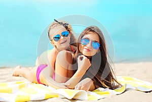 Summer vacation, relaxation, travel - mother and child lying resting on beach