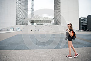 Summer vacation. Sightseeing guide. Girl tourist sunglasses enjoy city center square. Woman stand in front of urban