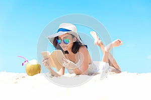 Summer Vacation. Smelling asian women relaxing, reading book and drinking coconut cocktail on the beach, so happy and luxury in ho