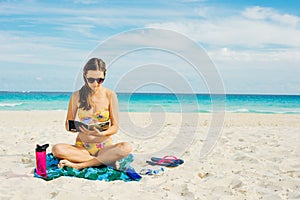 Summer Vacation. Smelling tourist women relaxing and reading book with sunglasses in beach