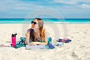 Summer Vacation. Smelling tourist women relaxing and reading book with sunglasses in beach