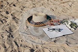 Summer vacation still life. Picnic on golden Mediterranean.beach sand. Straw hat, glasses of red wine and olive branches