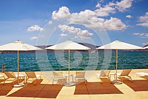 Summer vacation. Sun umbrellas and chaise lounges on the beach. Montenegro