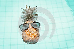 Summer Vacation and Swimming Pool Relaxation Lifestyles Concept, Pineapple With Sunglasses in Poolside at The Beach Vacations.