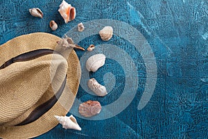 Summer vacation, tourism, travel, holiday concept. Sea shells, beach hat and blue colors on wooden background. Top view with space