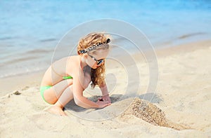 Summer vacation, travel concept - little girl child on beach playing