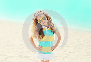 Summer vacation, travel concept - little girl child on beach wearing a sunglasses