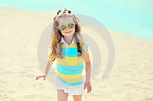 Summer vacation, travel concept - little girl child on beach wearing sunglasses