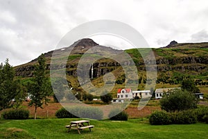 Summer vacation. Travelling and wanderlust. Mountain village on cloudy sky in Sejdisfjordur, Iceland. Country houses on