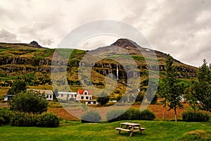 Summer vacation. Travelling and wanderlust. Mountain village on cloudy sky in Sejdisfjordur, Iceland. Country houses on