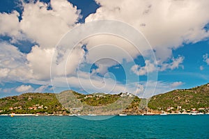 Summer vacation on tropical island. Mountain shore in blue sea on cloudy sky in gustavia, st.barts. Wild nature and