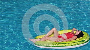 Summer vacation woman in bikini on inflatable avocado