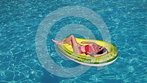 Summer vacation woman in bikini on inflatable avocado