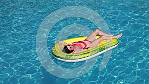 Summer vacation woman in bikini on inflatable avocado
