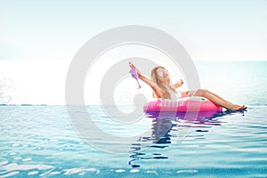 Summer Vacation. Woman in bikini on the inflatable donut mattress in the SPA swimming pool.