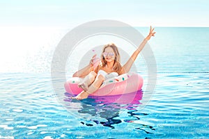 Summer Vacation. Woman in bikini on the inflatable donut mattress in the SPA swimming pool.