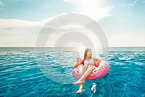 Summer Vacation. Woman in bikini on the inflatable donut mattress in the SPA swimming pool. Beach at the blue sea.