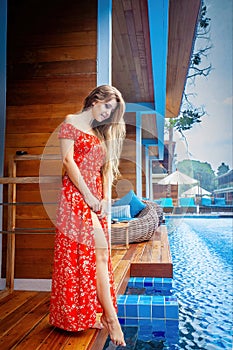 Summer vacationer enjoys the sun and water at a tropical resort pool.