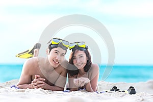 Summer Vacations. Beach travel couple having fun snorkeling. Asian smiling Couple lying and enjoy on summer beach sand with snorke