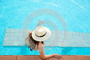 Summer Vacations. Lifestyle woman happy with bikini and big hat relaxing on the swimming pool,