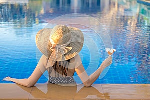 Summer Vacations. Lifestyle woman happy with bikini and big hat relaxing on the swimming pool, in holiday.