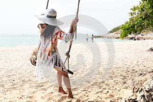 Summer Vacations. Lifestyle women relaxing and enjoying swing on the sand beach, fashion stunning young people