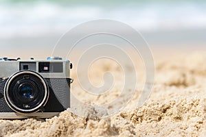 Summer Vacations. Vintage old camera of tourism on sandy beach.