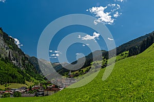 Summer valley with Grossarler Ache small river and blue cloudy sky