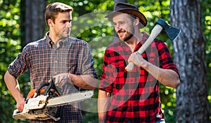 Summer vibes. deforestation. ranger or poach. man forester use saw and axe. search firewood for picnic campfire photo