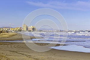 Summer vibes on the sunny autumn beach of Malvarrosa in Valencia, Spain. Vast expanses of smooth fine sand on the sea coast