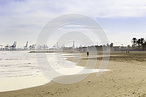 Summer vibes on the sunny autumn beach of Malvarrosa in Valencia, Spain. Vast expanses of smooth fine sand on the sea coast