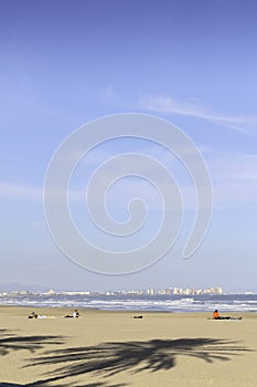 Summer vibes on the sunny autumn beach of Malvarrosa in Valencia, Spain. Vast expanses of smooth fine sand on the sea coast