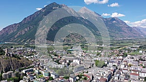 Summer view from drone of Martigny town in green valley on banks of Rhone river surrounded by Alps, Switzerland
