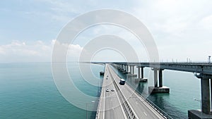 Summer view from a helicopter. Action. A huge bridge for moving cars made high above the sea and the blue daytime sky.