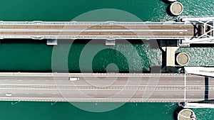 Summer view from a helicopter. Action. A huge bridge for moving cars made high above the sea and the blue daytime sky.