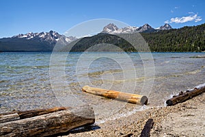 Summer view at Redfish Lake, located outside Stanley Idaho in the Sawtooth National Forest wilderness. Logs in foreground