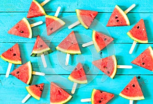 the summer watermelon slice popsicles on a blue rustic wood back