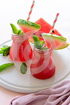 Summer watermelon smoothie decorated mint leaves on pink background. Summer drink concept