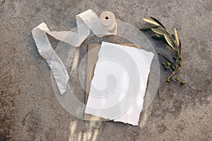 Summer wedding stationery, birthday mock-up scene. Blank greeting card, white silk ribbon and olive tree branches