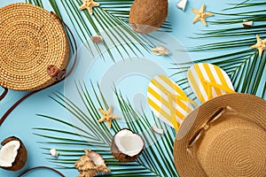 Summer weekend concept. Top view photo of round rattan bag yellow striped slippers hat sunglasses coconuts starfishes shells and